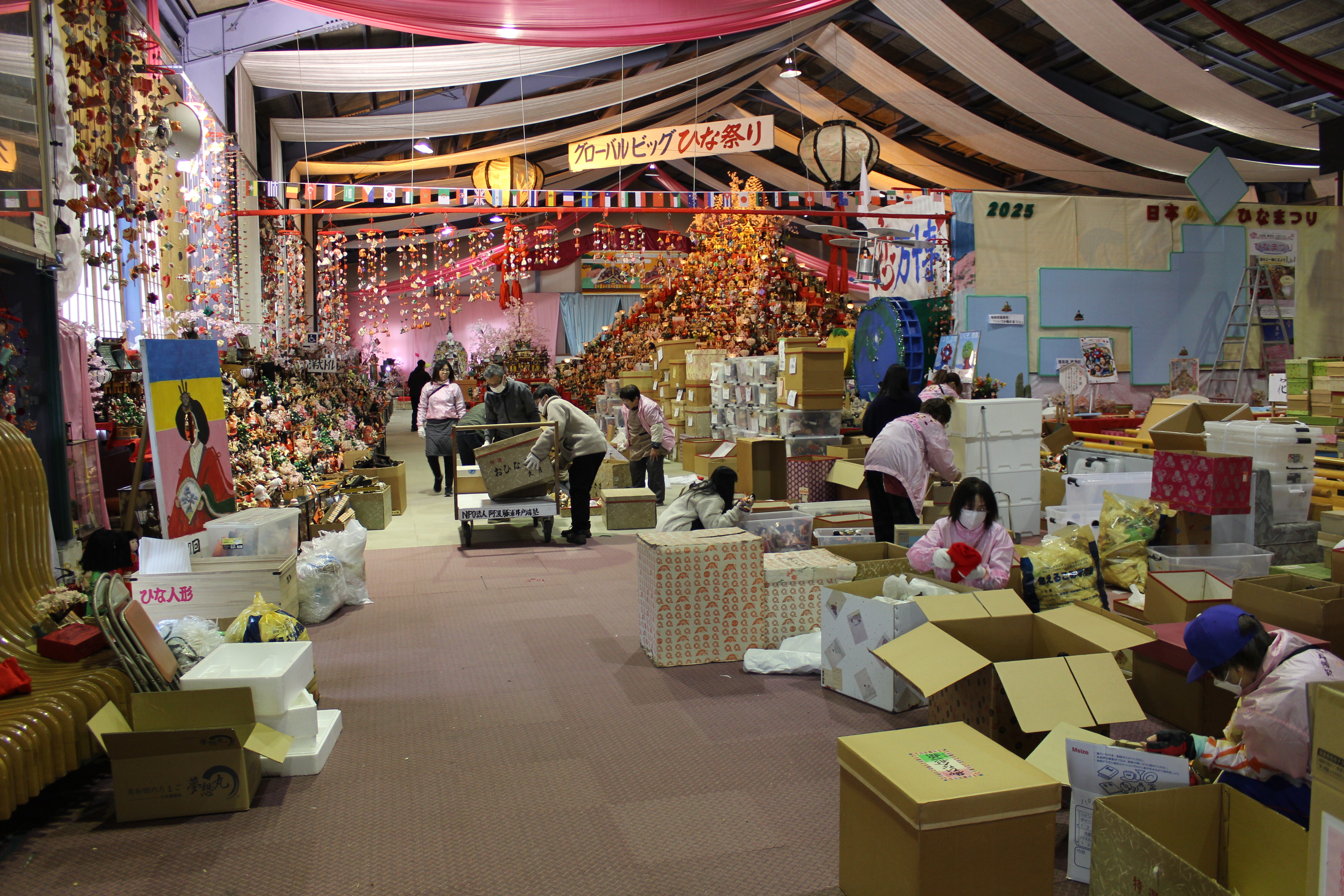 広い部屋でひな人形の展示の準備を行う様子