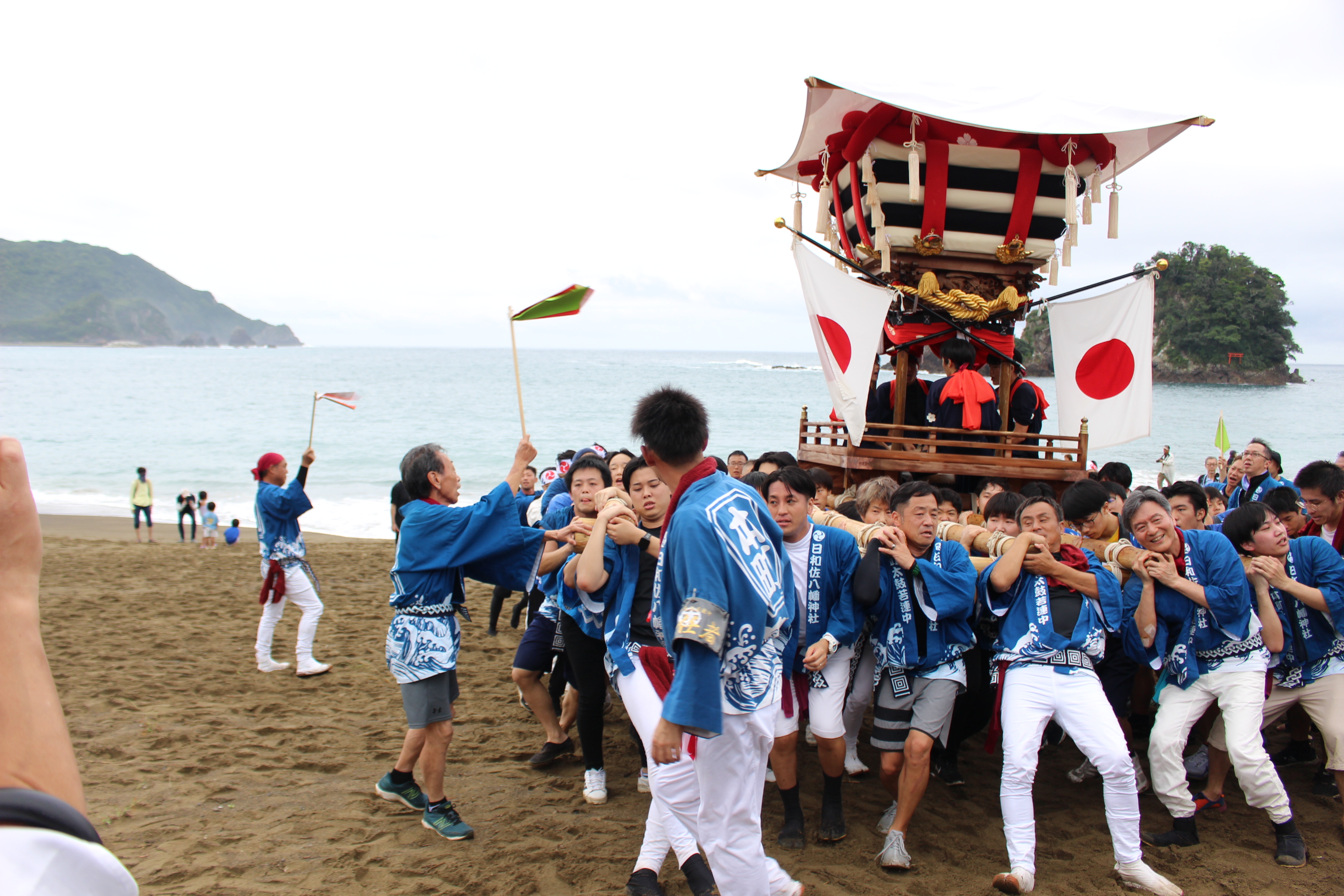 神輿を担ぎ海岸に出る様子