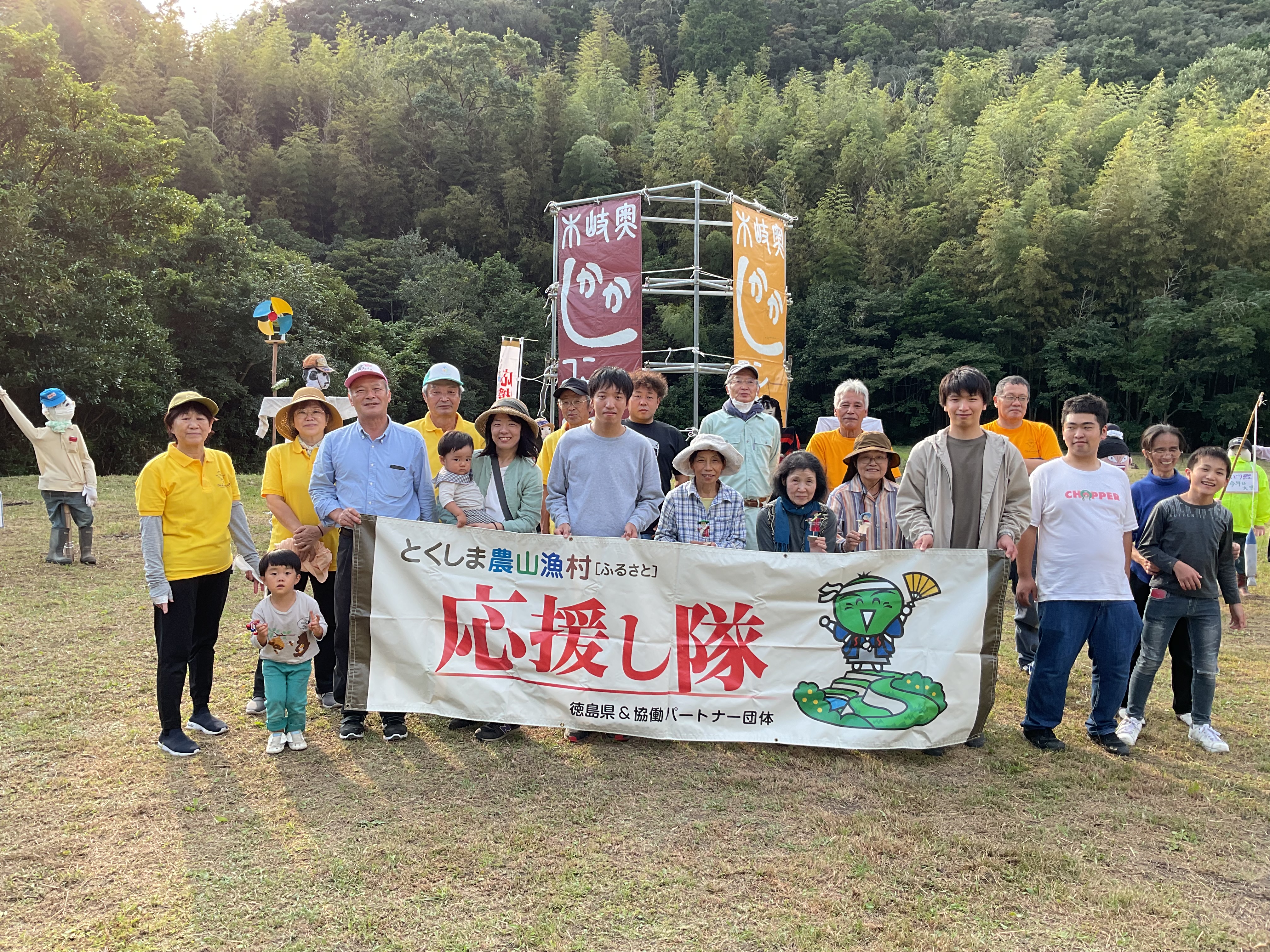 応援し隊の横断幕を持って20名程度が集まった集合写真