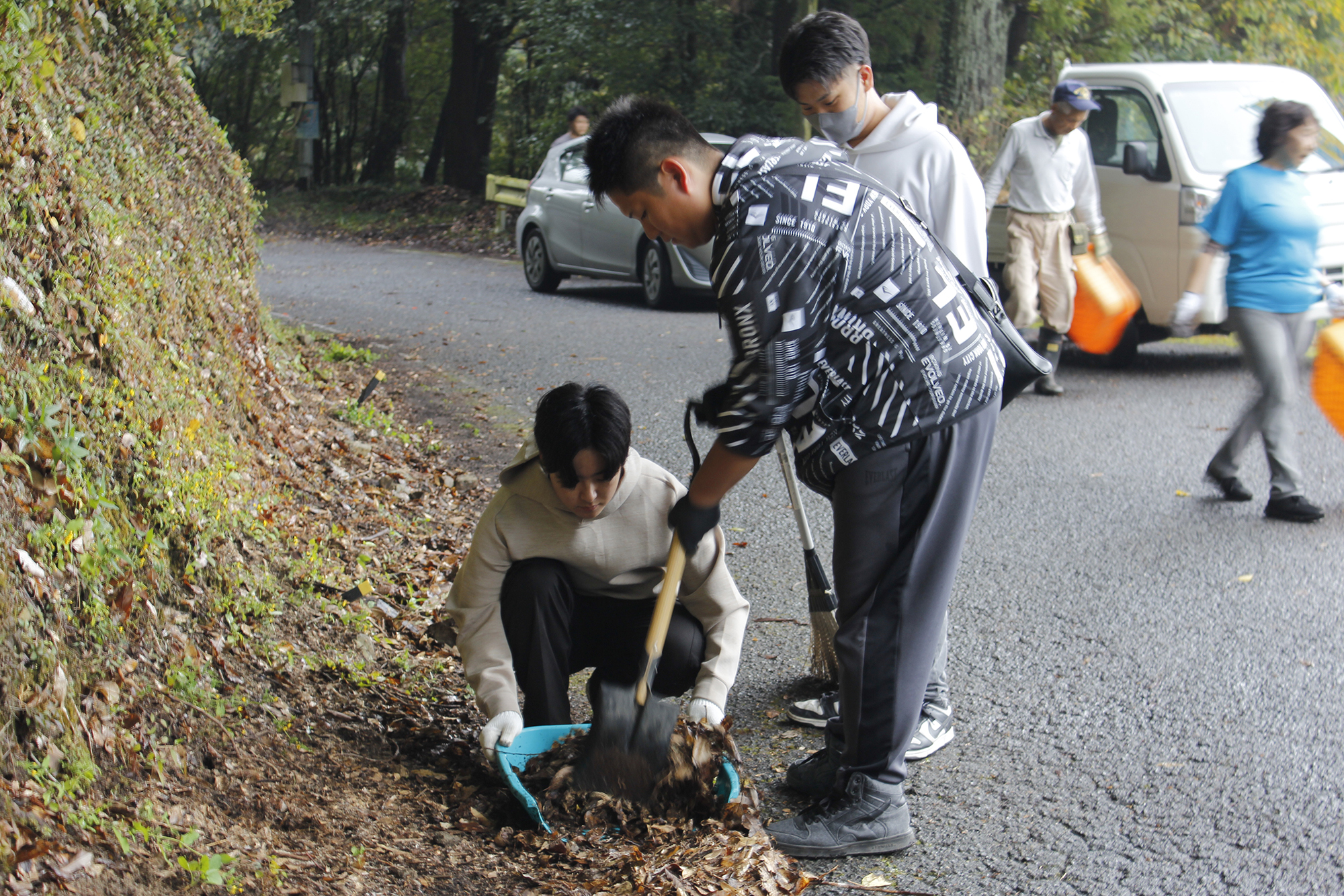 二人一組で落ち葉の清掃を行う様子