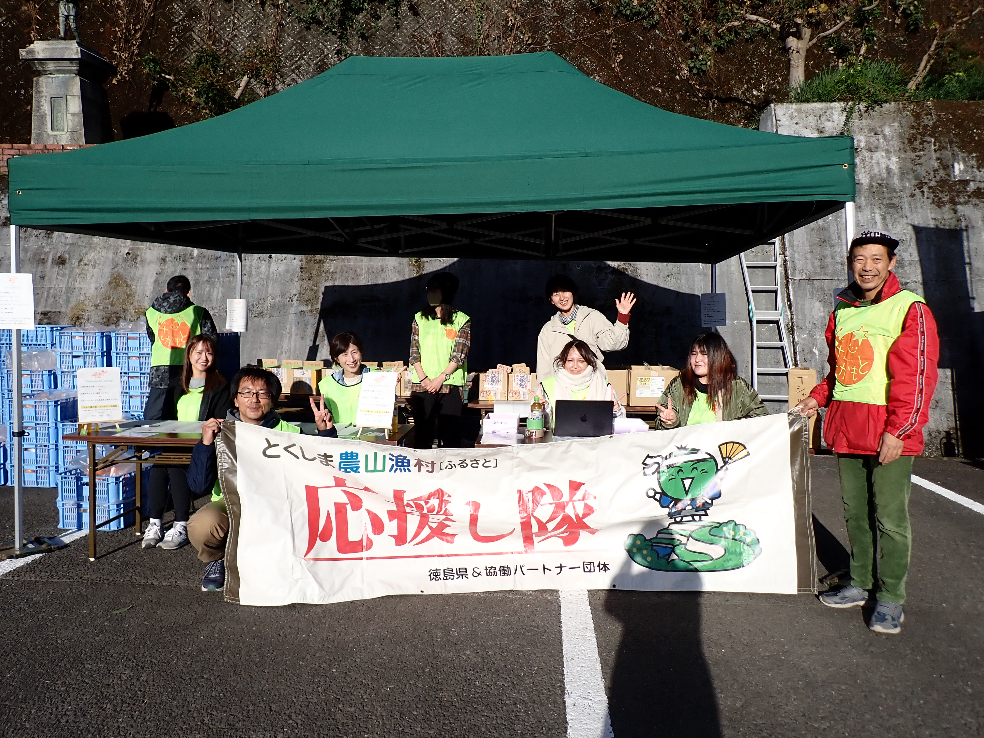 応援し隊の横断幕を持ち8名が集まった写真