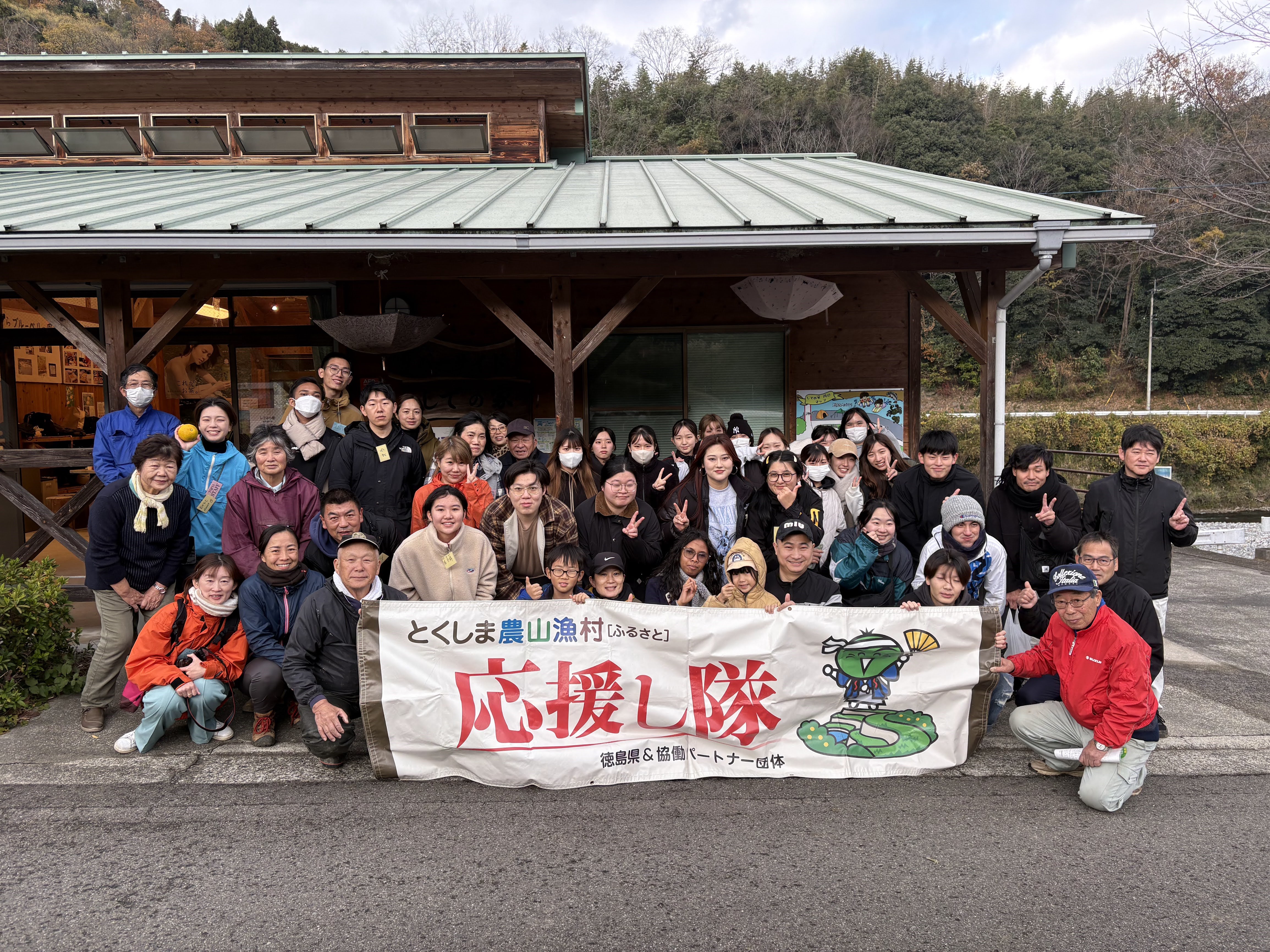 15日に集まった50名程度と横断幕の写真