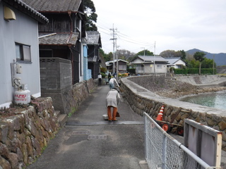 道路を箒で掃いている写真です。