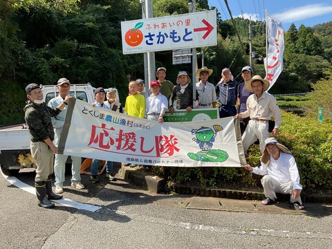 『ふれあいの里さかもと』の看板を背に集合写真です