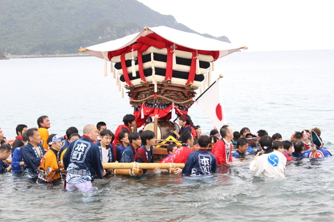 大勢で担いだちょうさが海に飛び込んでいます