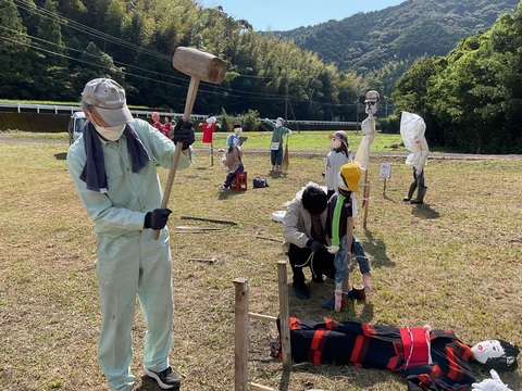 大きな木槌でかかしの支柱を打ち立てています