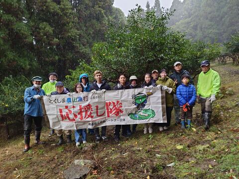 雪の降る中ゆずの木を背景に集合写真です